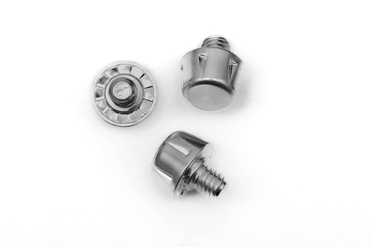 A pair of WRS All Surface/All Weather M6 Stud Kit from Starlai Corp and a bolt on a white surface ideal for converting soft ground boots.