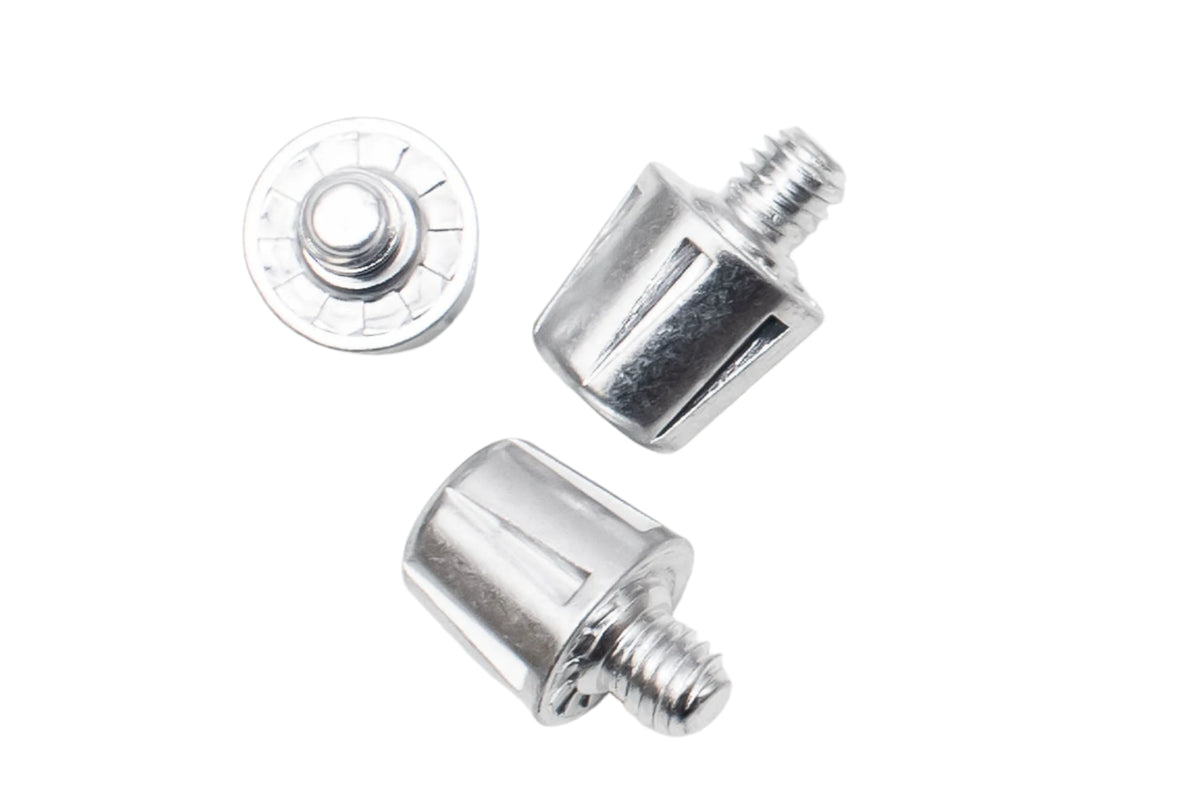 A pair of WRS All Surface/All Weather M6 Stud Kit chrome screws on a soft ground with an artificial grass surface by Starlai Corp.