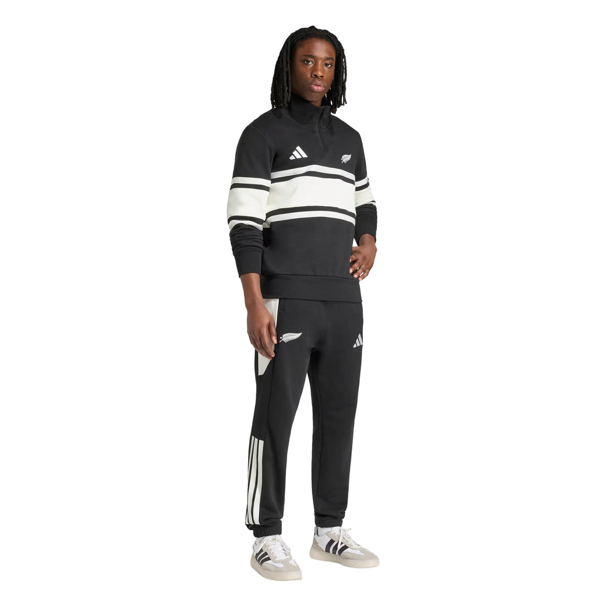 A person wearing the adidas All Blacks 26/27 Leisurewear 1/4 Zip Sweatshirt, posing against a plain white background.