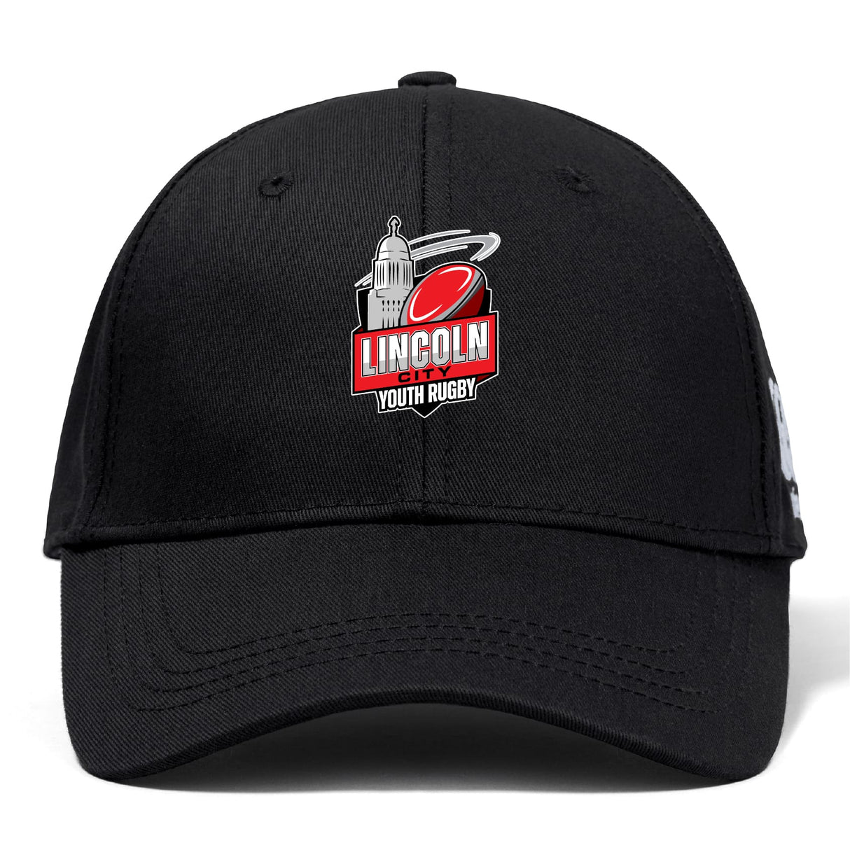 The Lincoln City Youth Rugby Flexfit Drill Cap by EMB Canterbury is a black curved brim cap featuring a red rugby ball and white building logo on the front.
