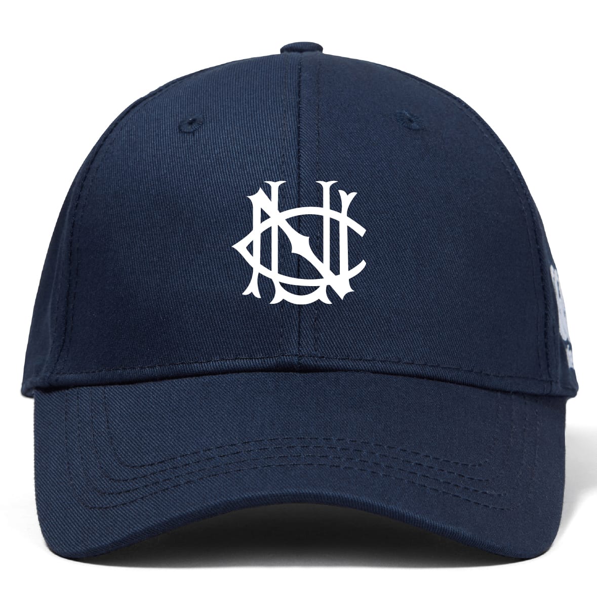 The UNC Rugby Flexfit Drill Cap by EMB Canterbury is a navy blue curved brim cap with a white embroidered stylized overlapping NS logo on the front panel.
