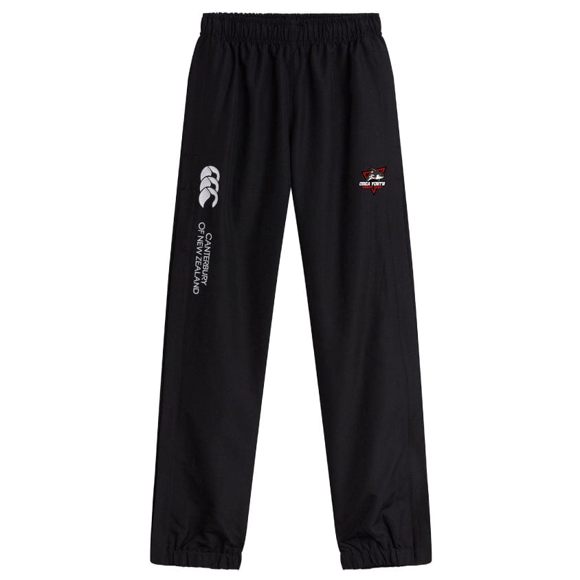 Orca Youth Cuffed Hem Stadium Pants by EMB Canterbury are black rugby pants designed with an elastic waistband and cuffed hems. They feature the classic white Canterbury New Zealand logo on the left leg and a distinctive red and white logo on the right.
