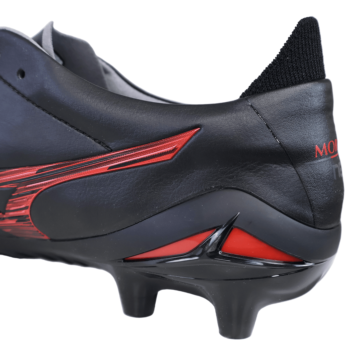Close-up of the heel and studs of a black and 40th Anniversary red Mizuno Morelia Neo IV FG Made in Japan Rugby Boot, highlighting the textured details and part of the Mizuno logo on the side—crafted from premium leather for outstanding quality.
