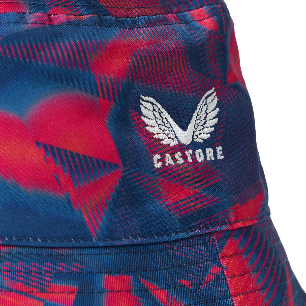 Close-up of the England 26/27 Reversible Bucket Cap by Castore, showcasing a blue and red patterned fabric with a white embroidered Castore wings logo. This lightweight bucket hat offers sun protection for outdoor activities and combines stylish design with practical comfort.