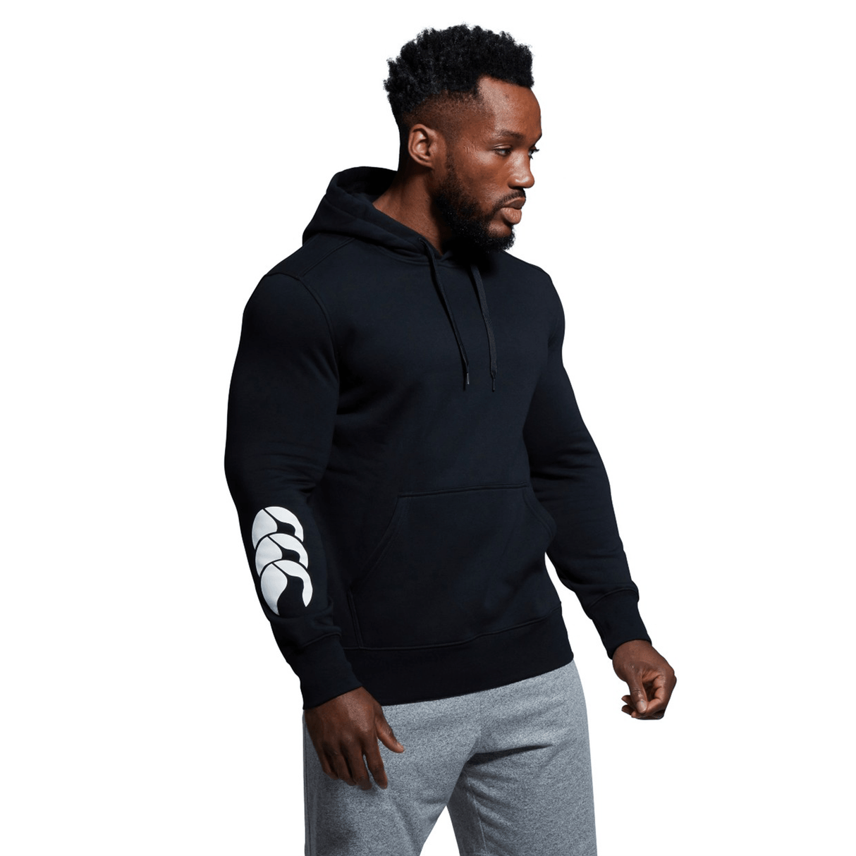 A man wearing a custom Canterbury Club Hoodie with sleeve branding, paired with sweatpants.