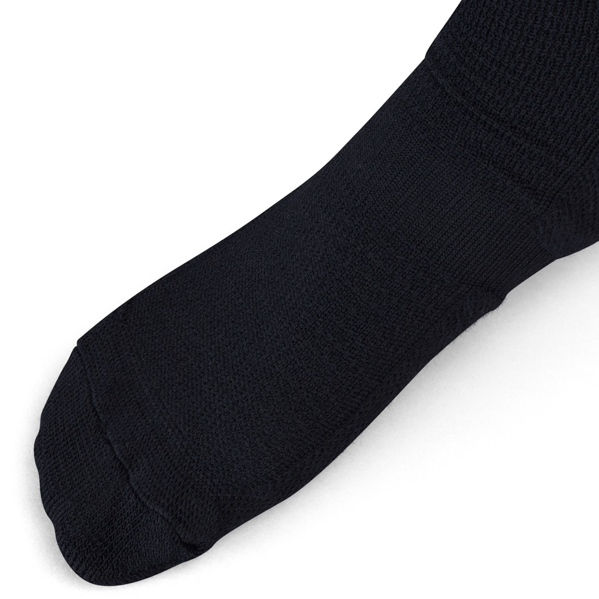 Close-up of a person's foot wearing a plain black sock, resembling the Ireland Alternate Socks by Canterbury, photographed on a white background.
