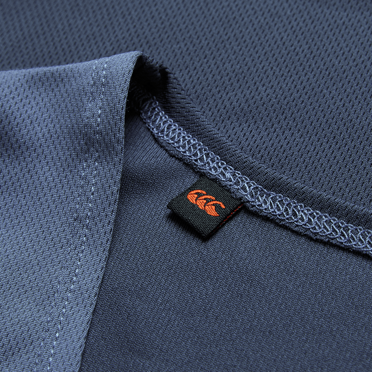 Close-up of the Ireland 26/27 Summer Tour Superlight Training Singlet by Canterbury, featuring detailed stitching and a small black tag with an orange logo.