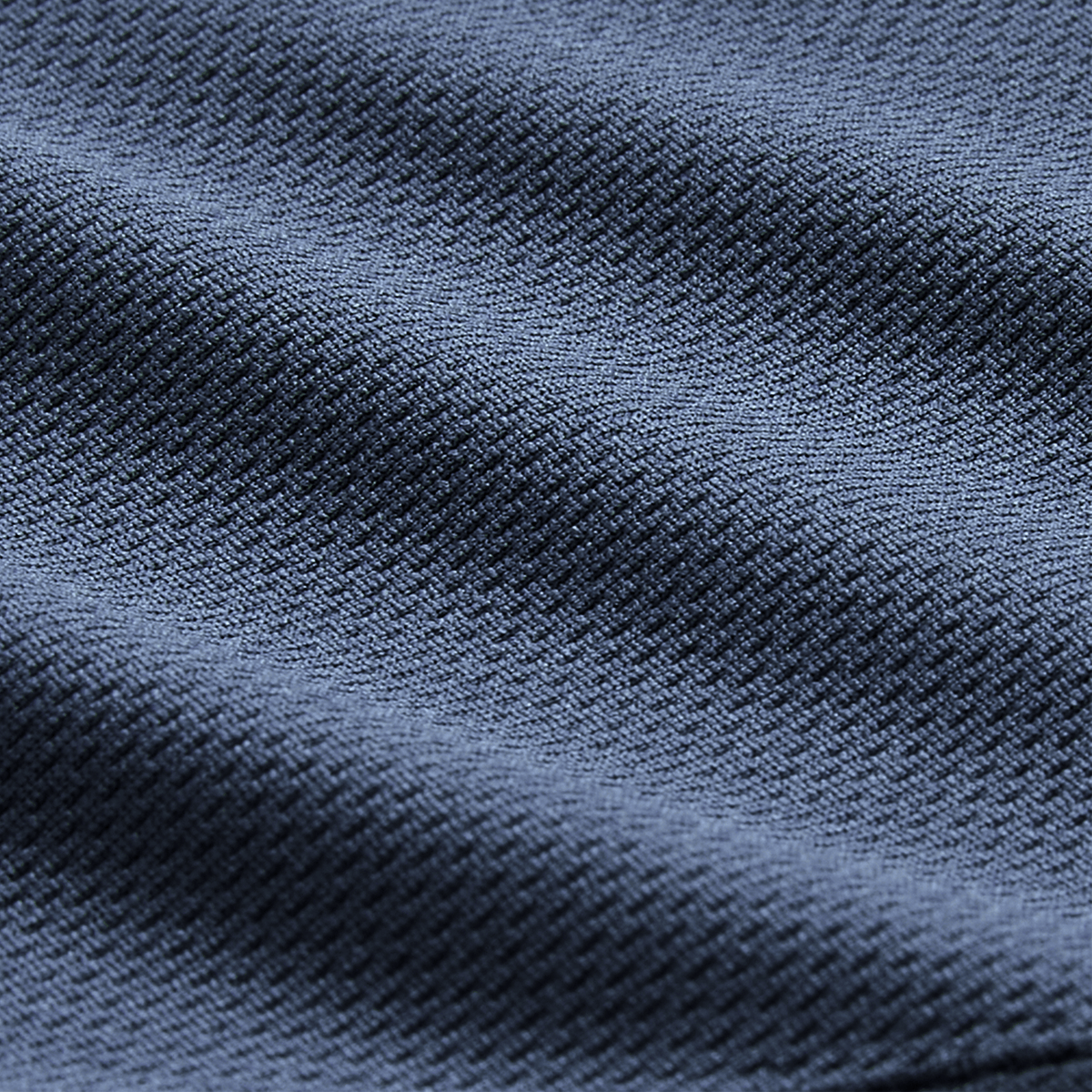 Close-up of dark blue textured fabric with a diagonal weave and soft folds, showcasing the premium quality of the Canterbury Ireland 26/27 Summer Tour Superlight Training Singlet.