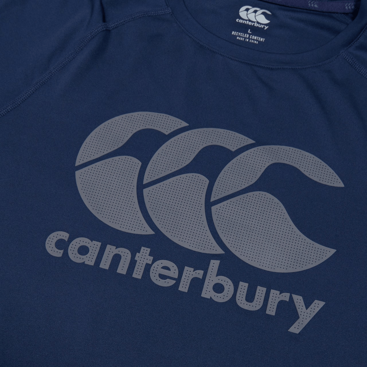 Close-up of the Canterbury Large Logo Superlight Tee, a lightweight performance shirt in blue with Canterbury’s name and logo in large gray print—ideal for rugby training.