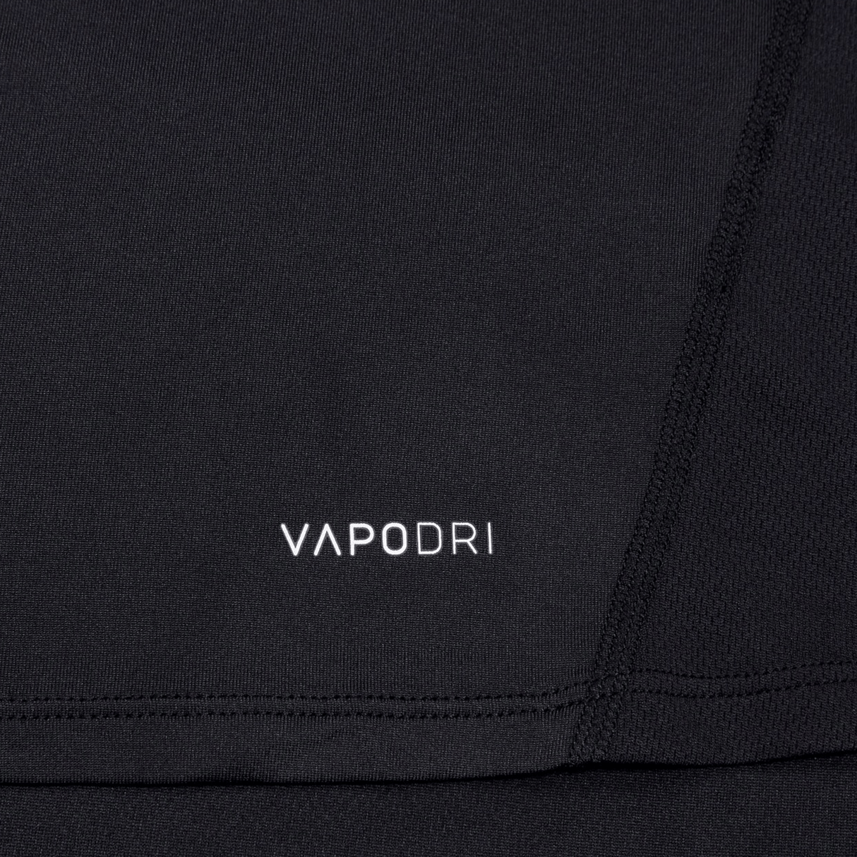 Close-up of a black Canterbury Large Logo Superlight Tee featuring "VAPODRI" in white text and visible seam stitching—a lightweight performance shirt from Canterbury, perfect for rugby training.