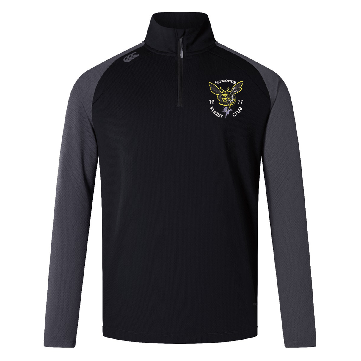 The Hornets Rugby Club 1977 Elite First Layer by EMB Canterbury is a black and gray long-sleeve quarter-zip pullover featuring VapoDri technology for advanced moisture management. It showcases an embroidered crest on the left chest that reads “Hornets Rugby Club 1977” along with a yellow hornet logo, making it the ideal rugby training top.