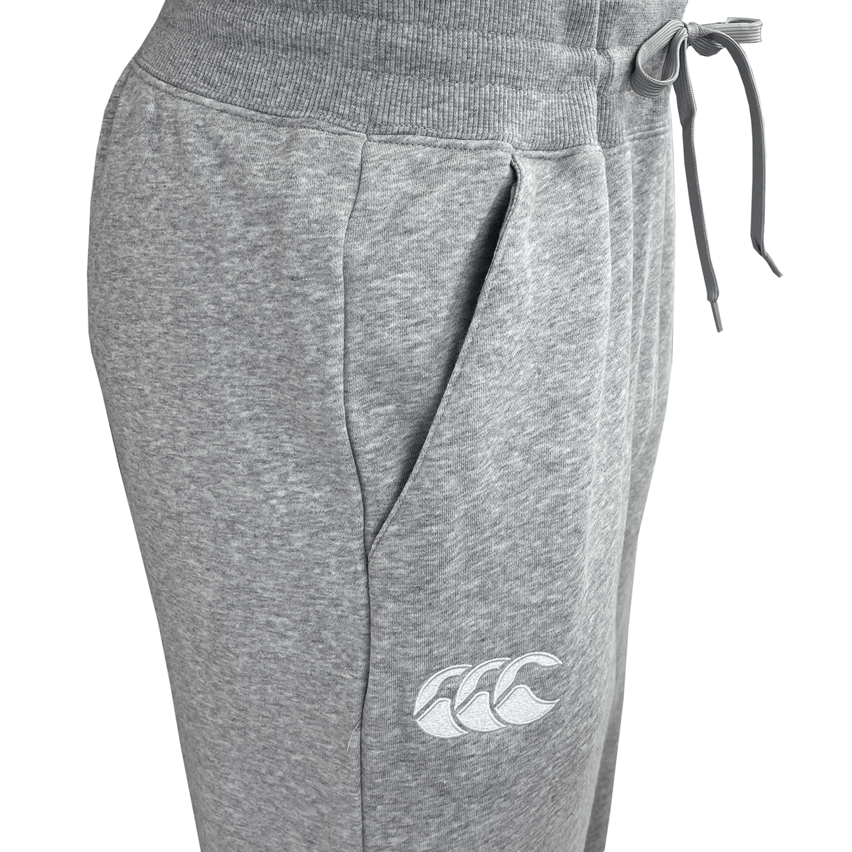 Close-up of the Canterbury Leisure Sweatpant by Canterbury, featuring an elastic waistband, drawstring, side pocket, and a logo of three waves on the upper thigh. Made from a sustainable blend for ultimate comfort in a stylish gray hue.