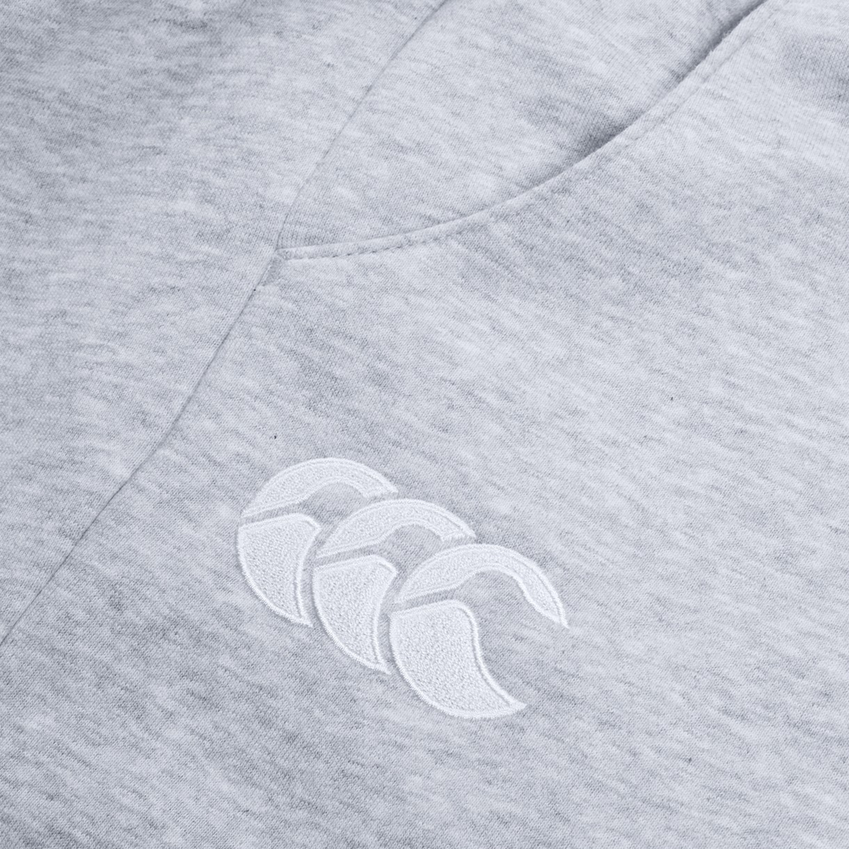 The Women's Leisure Sweatpant by Canterbury features a gray cotton blend fleece fabric with a white embroidered Canterbury logo showcasing three overlapping crescent shapes, ideal for casual wear.