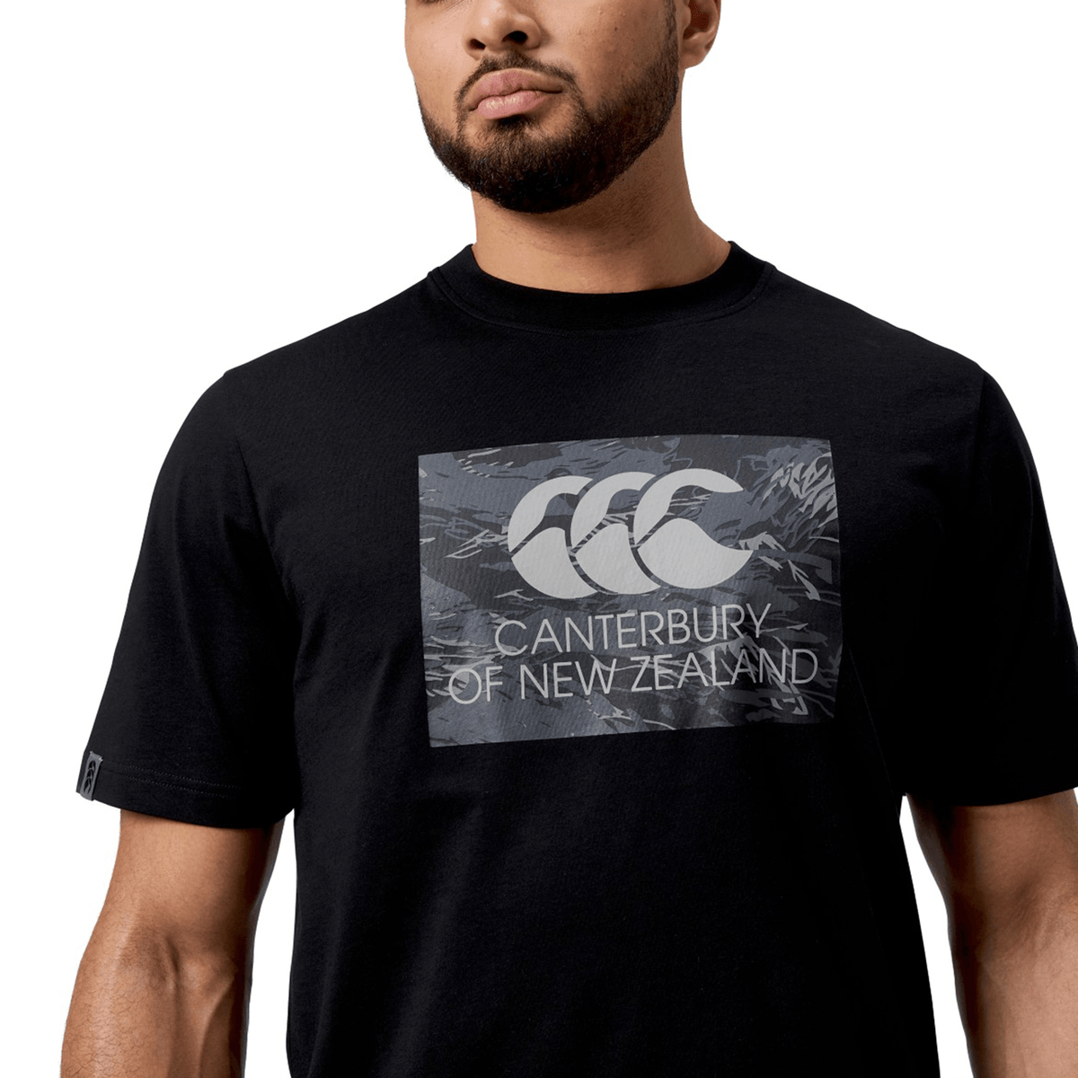 Someone in a black Canterbury Force T-Shirt with the "Canterbury of New Zealand" logo, offering a relaxed fit ideal for casual occasions.
