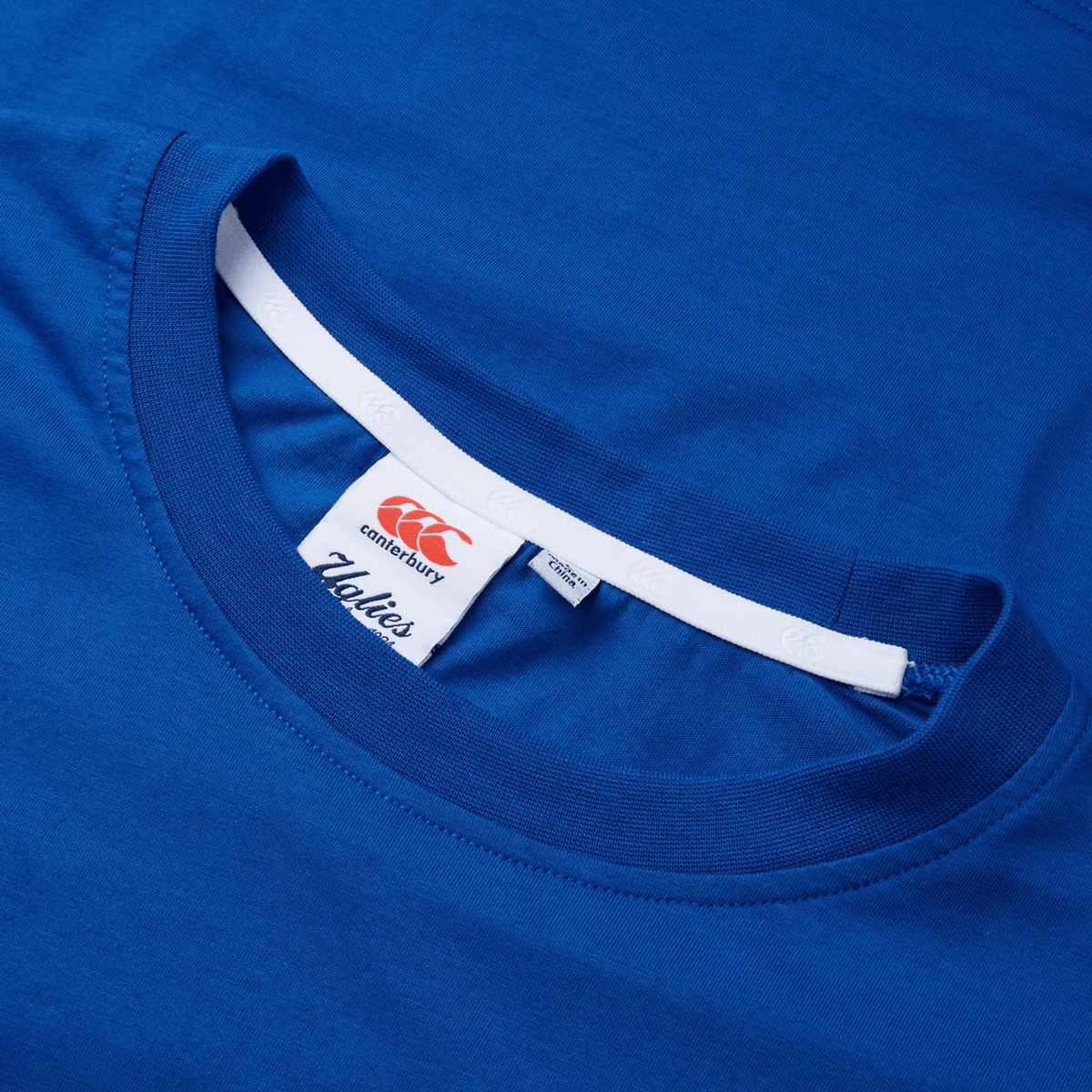 A close-up of the vibrant blue Canterbury Uglies T-Shirt highlights the neck label with the Canterbury logo and "Vapodri" text.