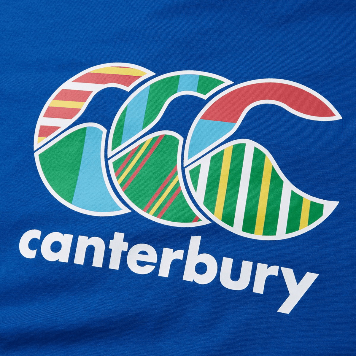 The Canterbury Uglies T-Shirt features a vibrant logo with overlapping "C"s adorned with striped and geometric patterns, echoing the dynamic designs of the shirt. This playful insignia appears above the brand name in crisp white text on a blue background.