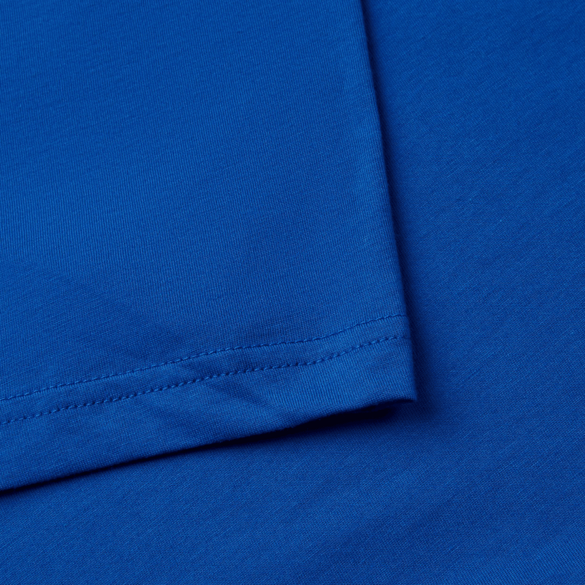 Close-up of a vibrant Canterbury Uglies T-Shirt by Canterbury, laid flat to highlight the hem and stitch detail on its premium cotton fabric.