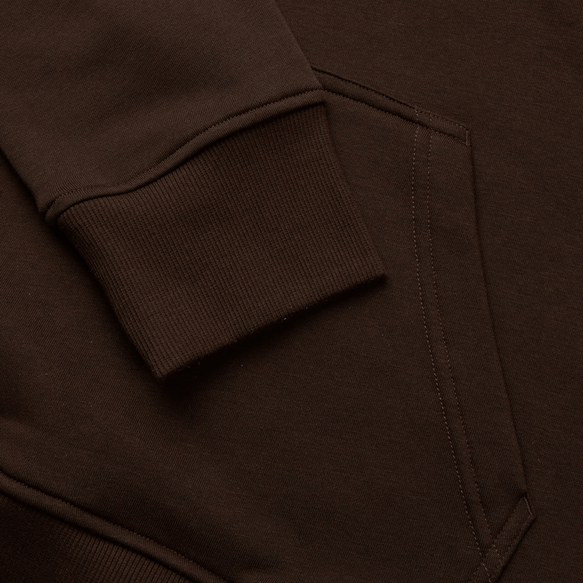 Close-up of a brown sweatshirt with ribbed cuffs and a side pocket, highlighted by bold colors reminiscent of the Canterbury Uglies Hoodie by Canterbury.