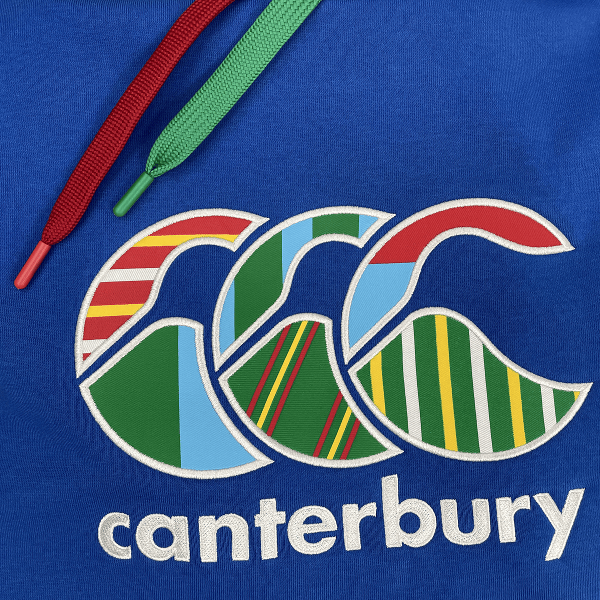 The Canterbury Uglies Hoodie boasts bold block colors, a stylized multicolored striped CCC logo, "Canterbury" branding below, and red and green drawstrings.