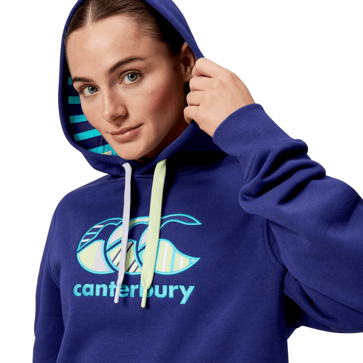 A person in a Canterbury Women's Uglies Hoodie, blue with the hood up, facing the camera.