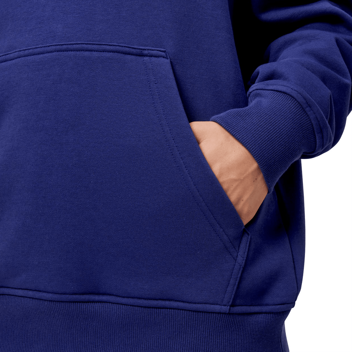 A person is wearing a vibrant, blue Canterbury Women's Uglies Hoodie with their right hand in the front pocket, showcasing its unique women's cut. Only the torso and part of the arm are visible.