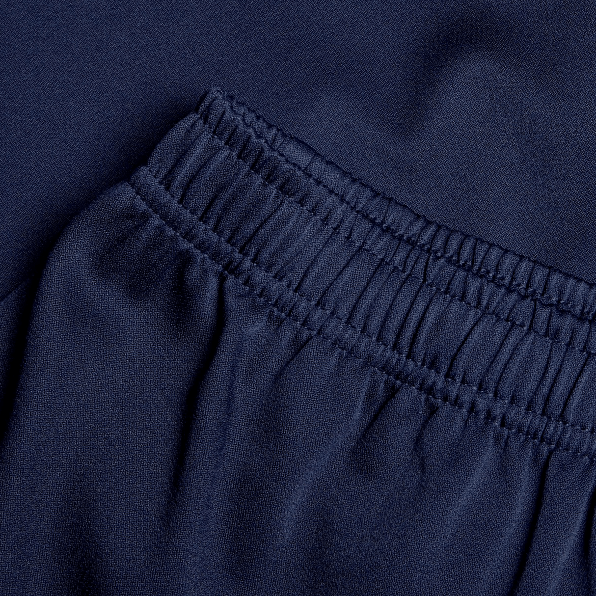 Close-up of navy blue fabric reveals an elastic waistband and gathered stitching, highlighting the durability of the Canterbury Professional Short 2.0.