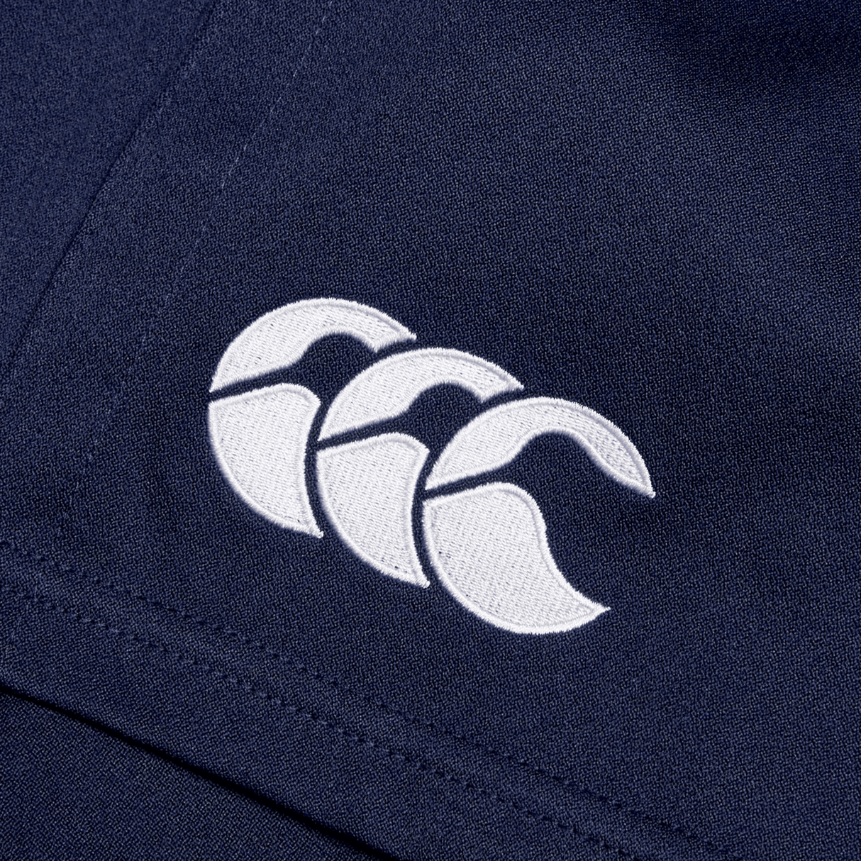 Close-up of Canterbury's Professional Short 2.0 in navy blue, showcasing a white embroidered logo with three wave-like shapes, emphasizing the adjustable fit and impressive durability.