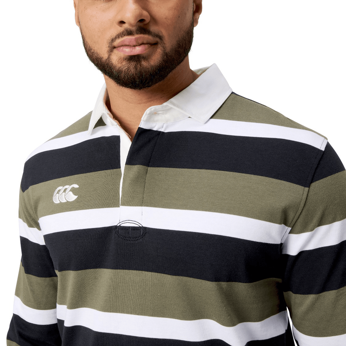 Someone is wearing the Canterbury Yarn Dye Long Sleeve Striped Rugby Jersey in dark green, black, and white stripes with a small logo on the left.