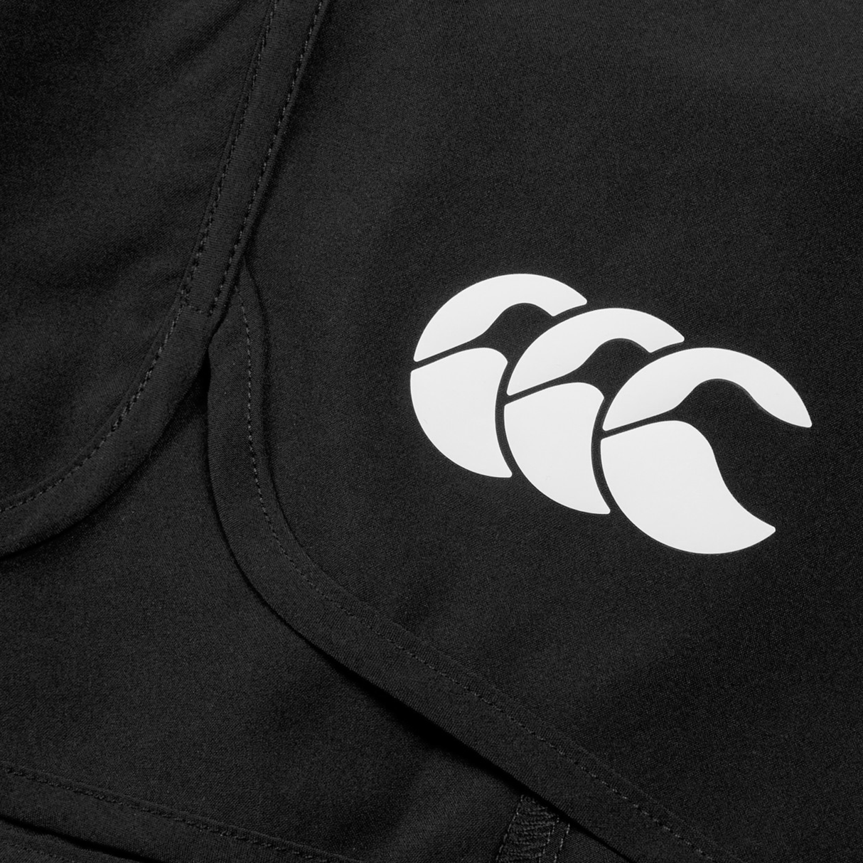 Close-up of the Women's Ireland 25/26 Woven Gym Short by Canterbury, in black, featuring the Canterbury logo with three stylized white wave shapes.