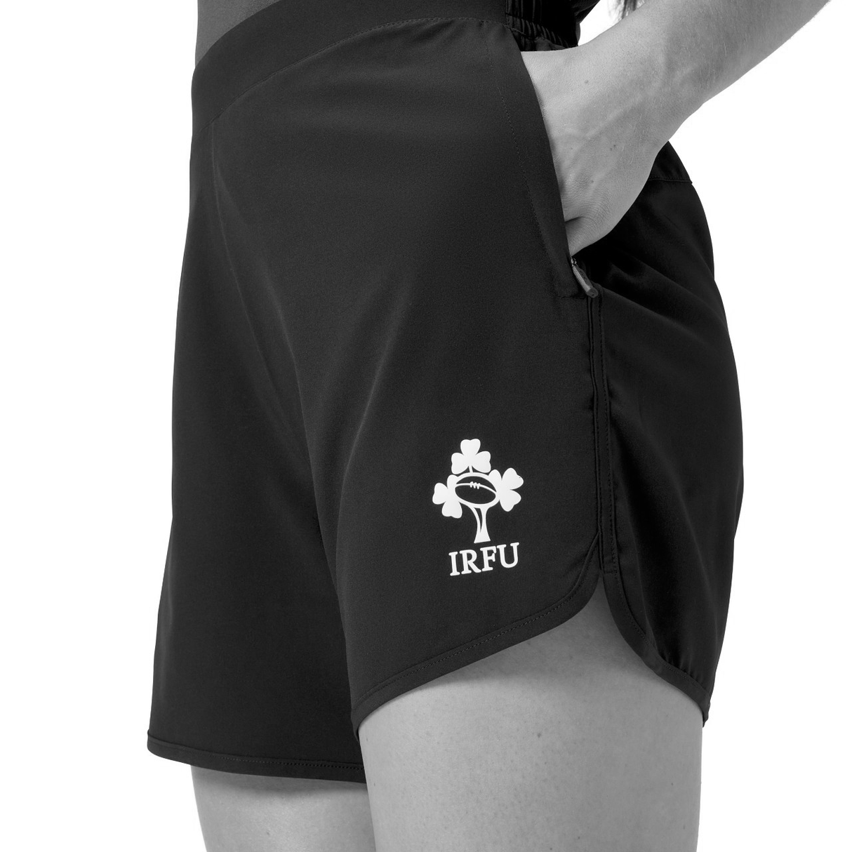 A person wearing Canterbury Women's Ireland 25/26 Woven Gym Shorts with a hand in the pocket, shown from waist to mid-thigh—ideal for Ireland women's rugby or as comfortable Canterbury gym shorts.