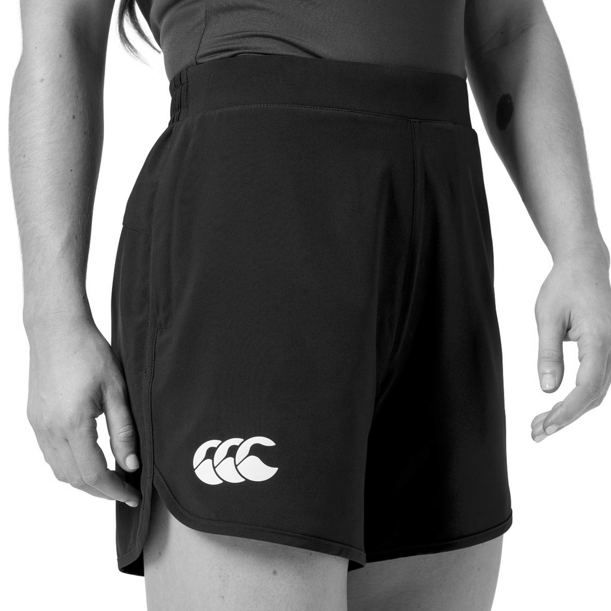 Model wearing Canterbury Women's Ireland 25/26 Woven Gym Shorts in black, featuring a white Canterbury logo on the left leg, shown waist to mid-thigh with one hand by her side.