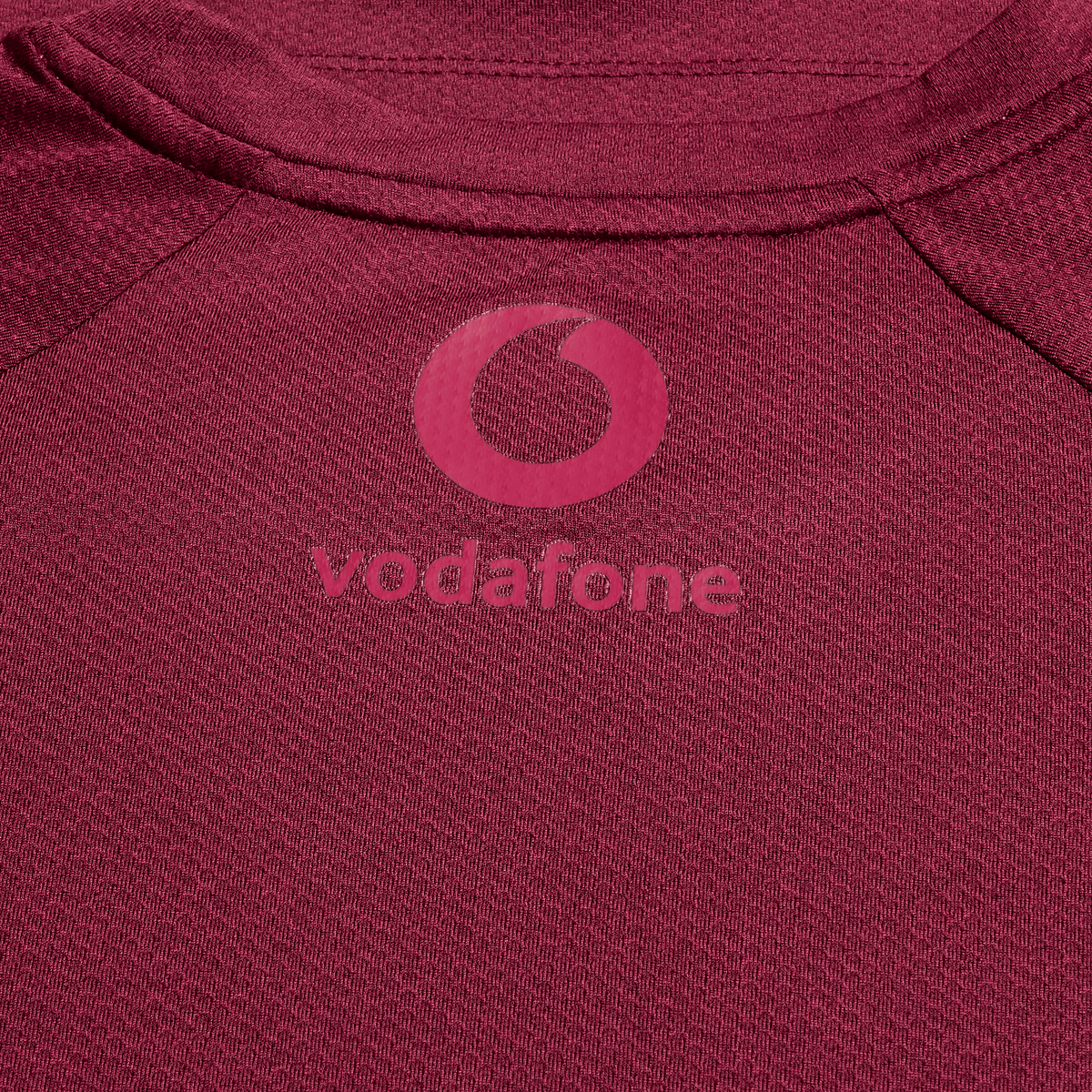 Close-up of the Canterbury Ireland 25/26 Autumn Internationals Elite Training Tee, showcasing the maroon Vapodri fabric and pink Vodafone logo.