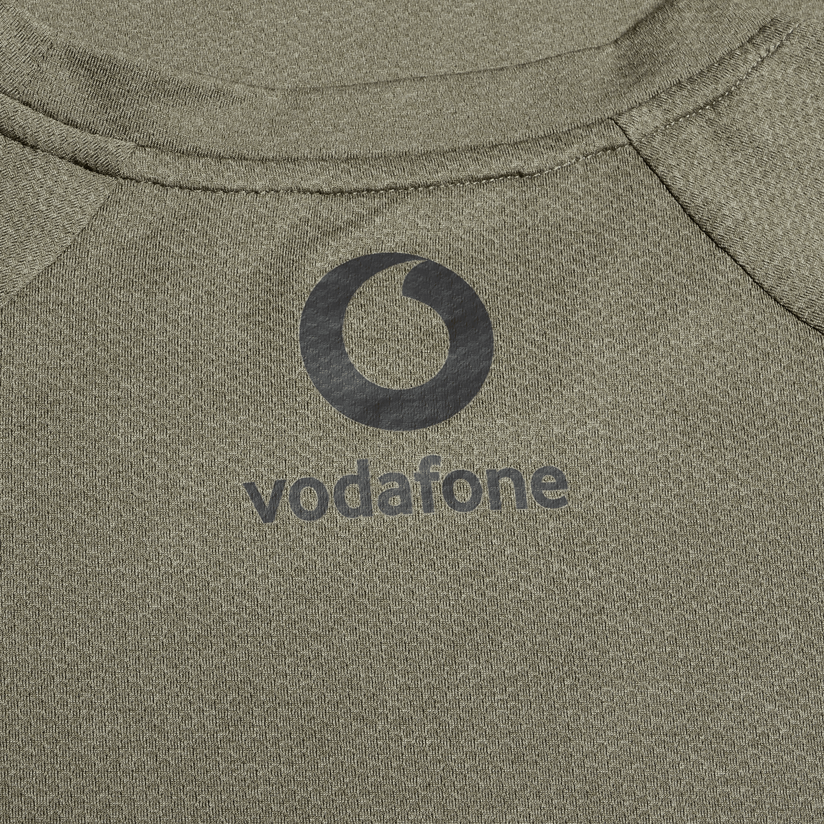 Close-up of the Ireland 25/26 Autumn Internationals Elite Training Tee by Canterbury in khaki, featuring the black Vodafone logo and Vapodri fabric for enhanced performance.