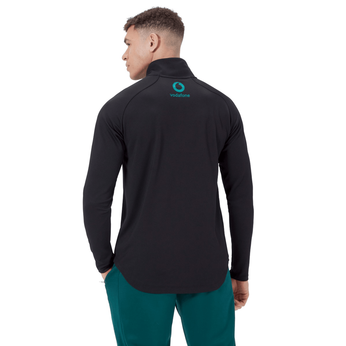 A man faces away from the camera wearing a black Canterbury Ireland 25 Elite First Layer training top with a Vodafone logo on the upper back.