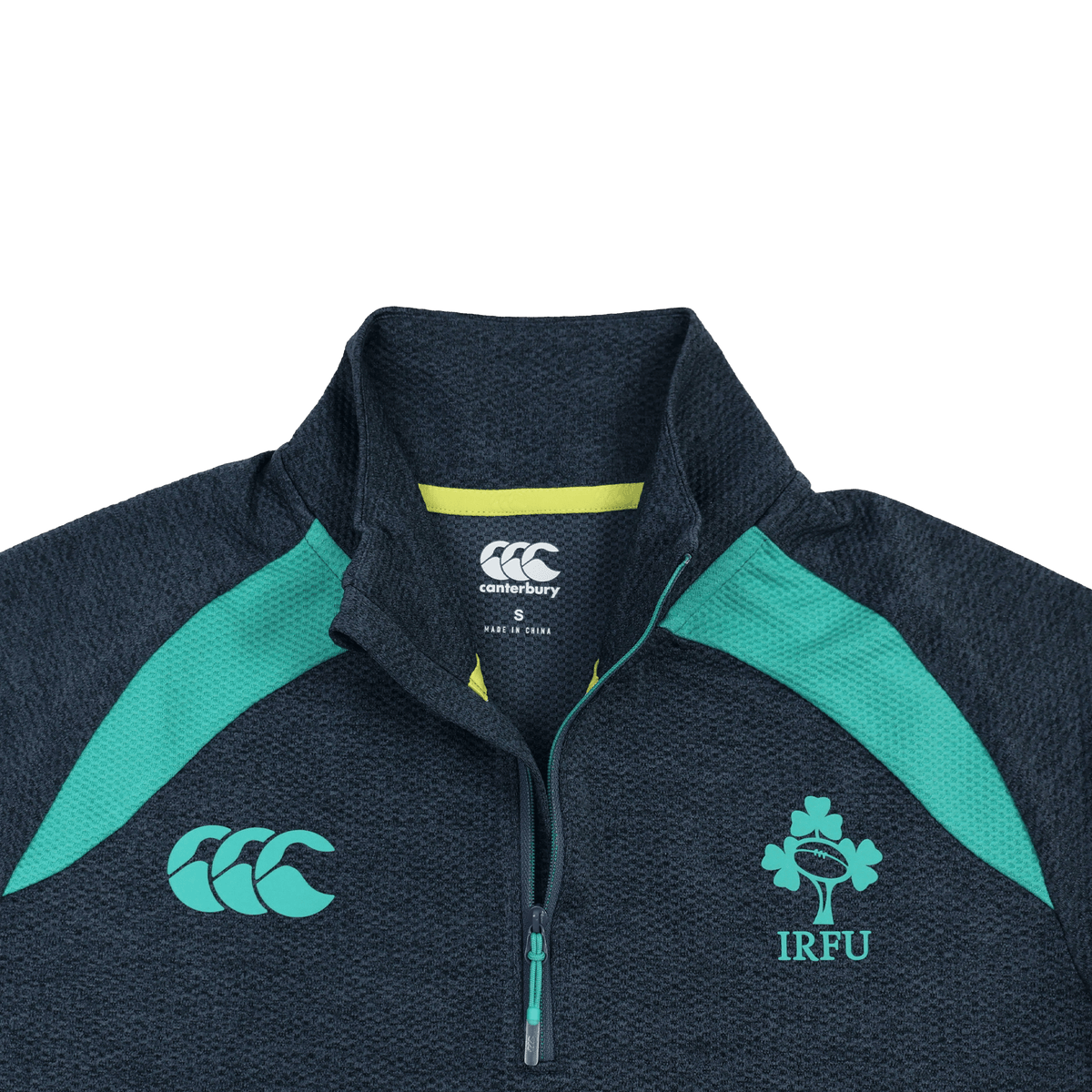 The Ireland 26/27 Summer Tour Elite First Layer by Canterbury is a dark grey lightweight quarter-zip with teal accents, IRFU shamrock and Canterbury logos, and Vapodri tech for comfort—part of the Elite range.