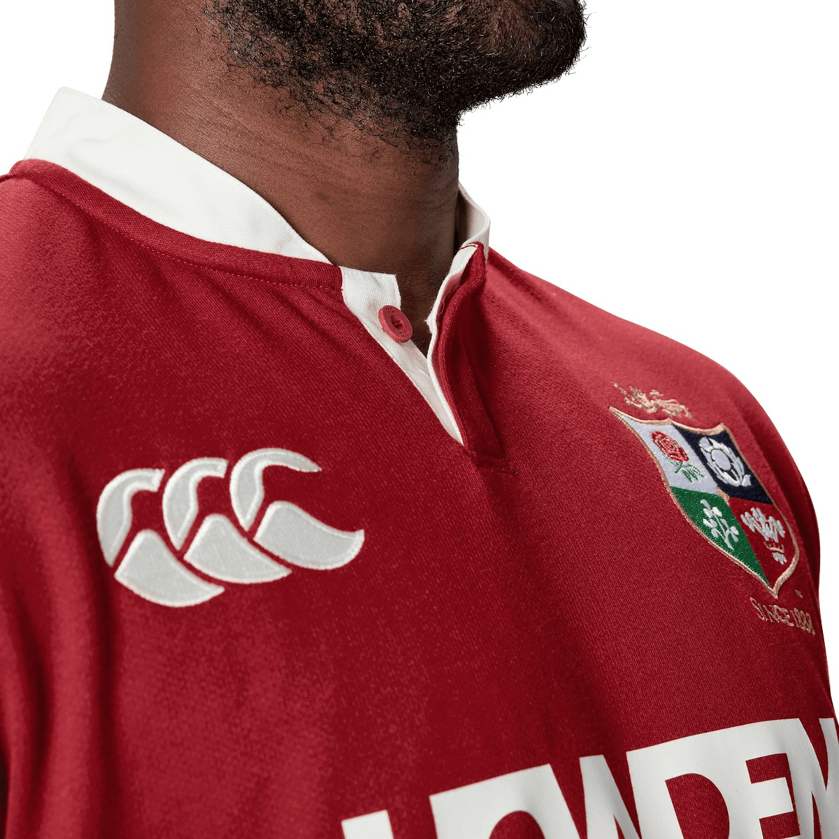 A man wearing the British & Irish Lions 2025 Classic Jersey by Canterbury, showcasing a traditional rugby style with white logos and a classic collar.