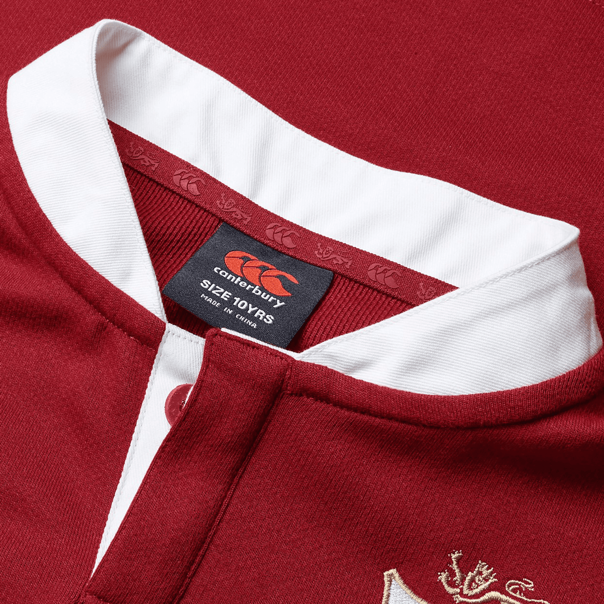 Close-up of the collar on the Youth British & Irish Lions 2025 Long Sleeve Classic Jersey by Canterbury, featuring a red and white design with a moisture-wicking fabric, and showcasing the Canterbury logo label with size details.
