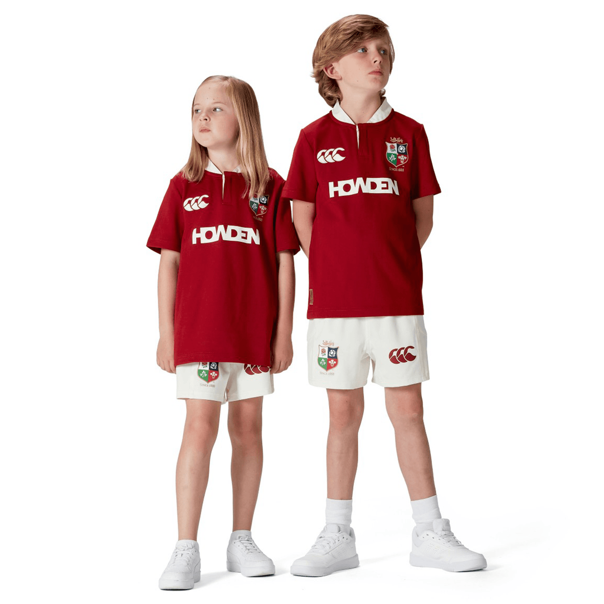 Two kids wear matching maroon Canterbury jerseys and white shorts, each in the Youth British & Irish Lions 2025 Classic Jersey style.
