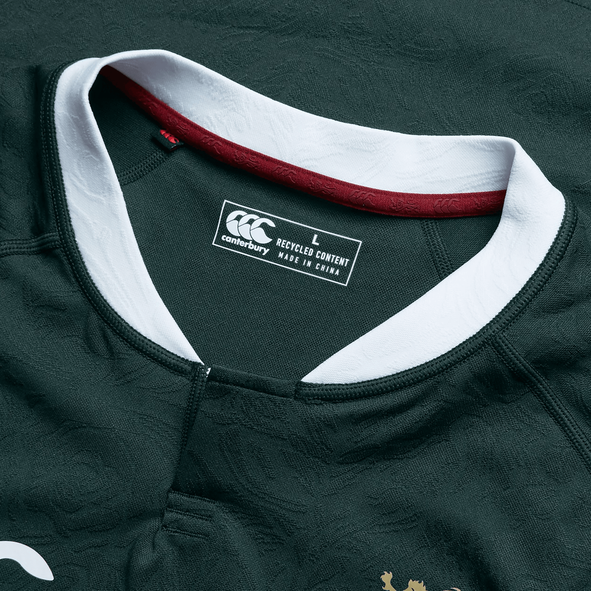 The British & Irish Lions 2025 Training Jersey by Canterbury is a dark green replica jersey with white and maroon accents. It features a Canterbury label specifying size L and "Made in China from Recycled Polyester," making it an ideal choice for eco-conscious fans.