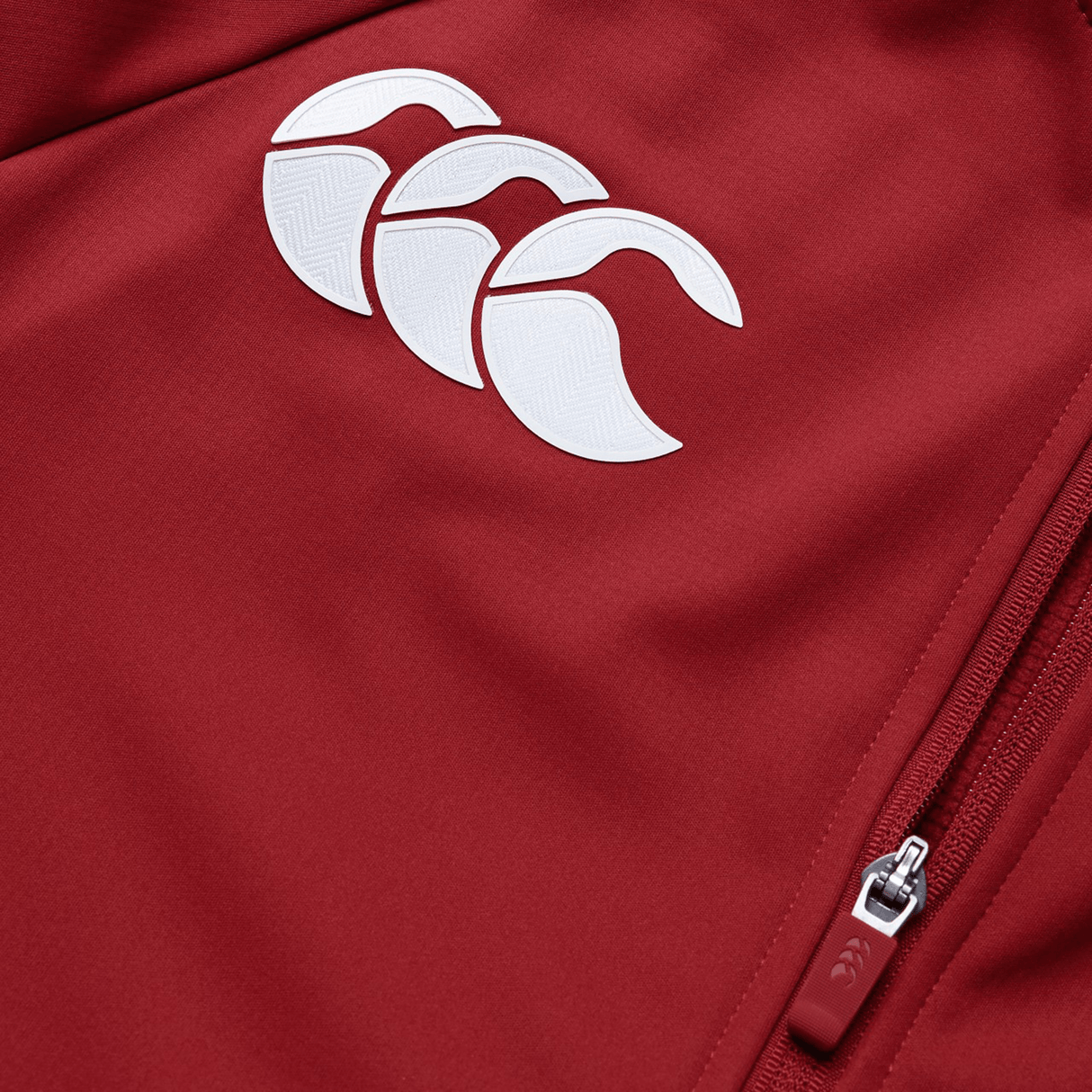 The British & Irish Lions 2025 Anthem Jacket by Canterbury is red with a white logo of three overlapping rugby ball shapes on the chest. It features a zippered pocket and showcases water-resistant qualities, making it perfect for unpredictable weather.