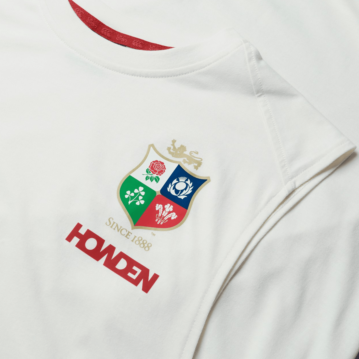 This British & Irish Lions 25 white cotton muscle tank by Canterbury showcases a vibrant crest with four emblems and the text "Since 1888" above "Howden" in bold red letters, reflecting Canterbury's classic style.