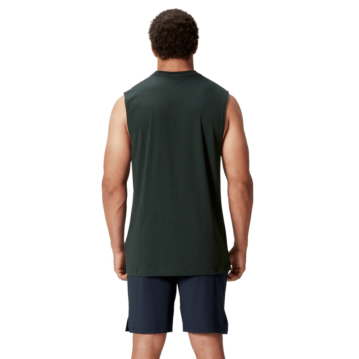 A person stands with their back to the camera, dressed in a dark sleeveless shirt and shorts that evoke the sporty spirit of Canterbury's British & Irish Lions 25 Cotton Muscle Tank.