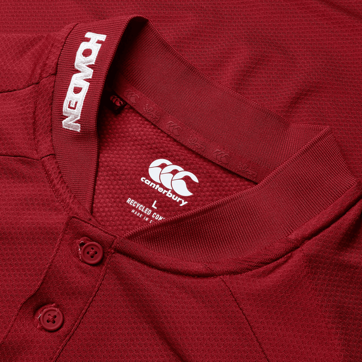 Close-up of a maroon British & Irish Lions 25 Poly Polo by Canterbury featuring a polo-style collar with buttons. The jersey showcases the Canterbury logo along with the text "REUSED" and "NEW ORIGINS" on the inner collar.