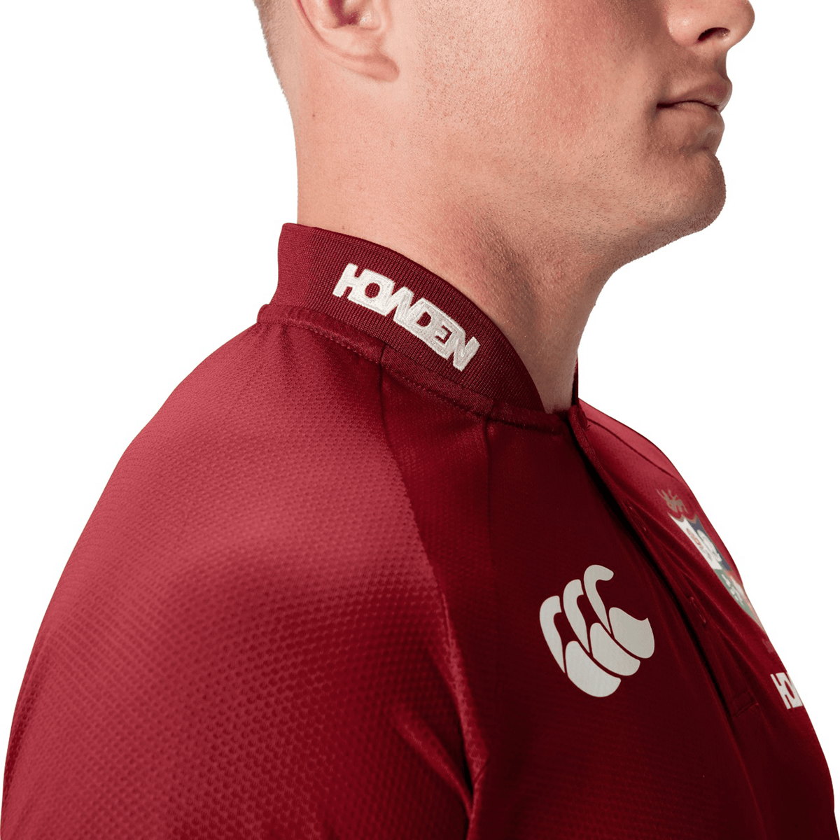 A man wearing the British & Irish Lions 25 Poly Polo by Canterbury, featuring logo details and made from breathable fabric, seen from the side.