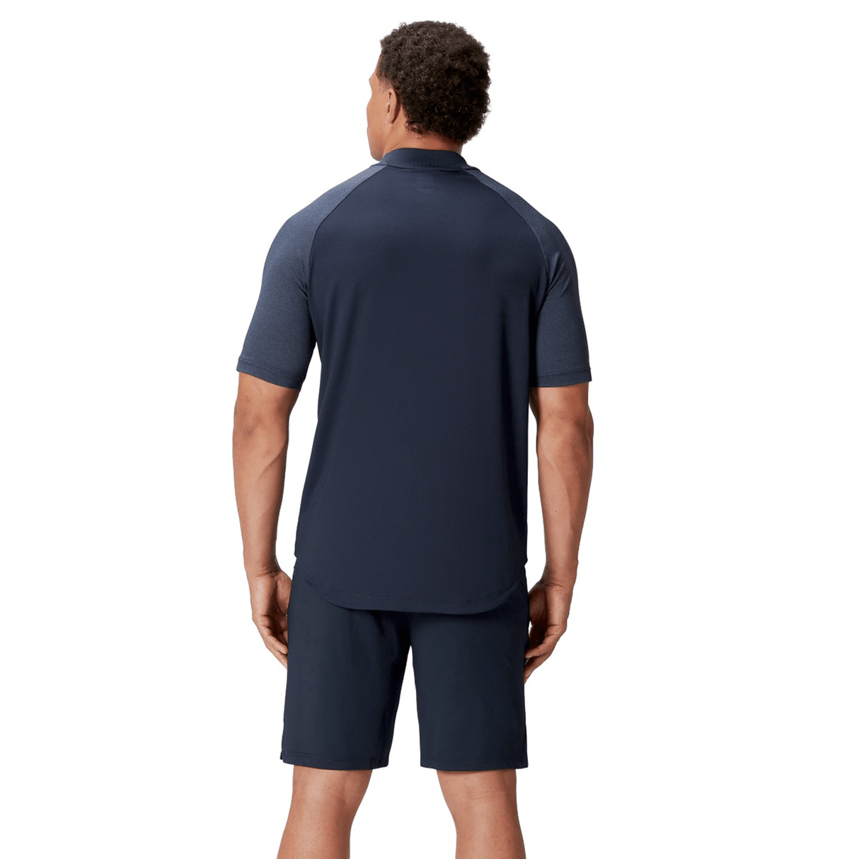A man in a British & Irish Lions 25 Poly Polo by Canterbury and shorts stands with his back to the camera against a plain white background. The quick-drying fabric guarantees comfort, making it ideal for any activity.