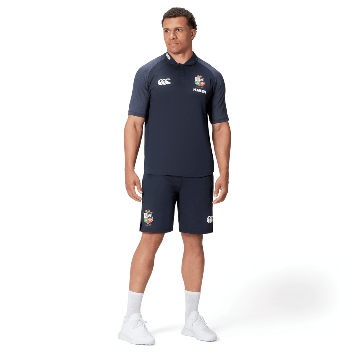 A man in a British & Irish Lions 25 Poly Polo by Canterbury, made from quick-drying fabric, is standing against a white background.