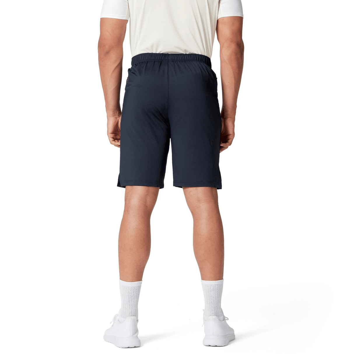 A person dressed in a white shirt, British & Irish Lions 2025 Training Short by Canterbury, white socks, and white shoes stands with their back to the camera.