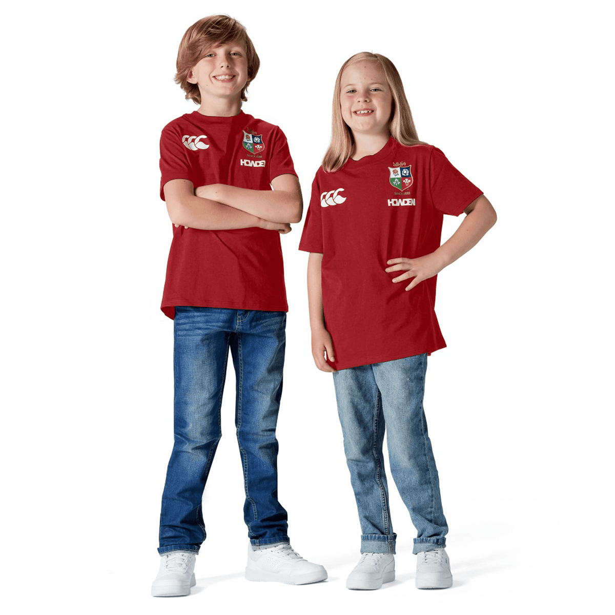 Two children in Youth British & Irish Lions 2025 Cotton Jersey Tees by Canterbury smile in a studio, proudly showing their support as young British & Irish Lions fans.