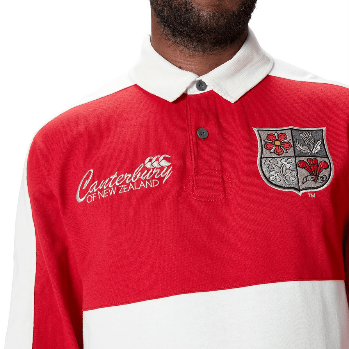 A person wearing the British & Irish Lions 2025 Heritage Jersey by Canterbury, crafted from a premium cotton blend, showcases an embroidered crest on the chest.