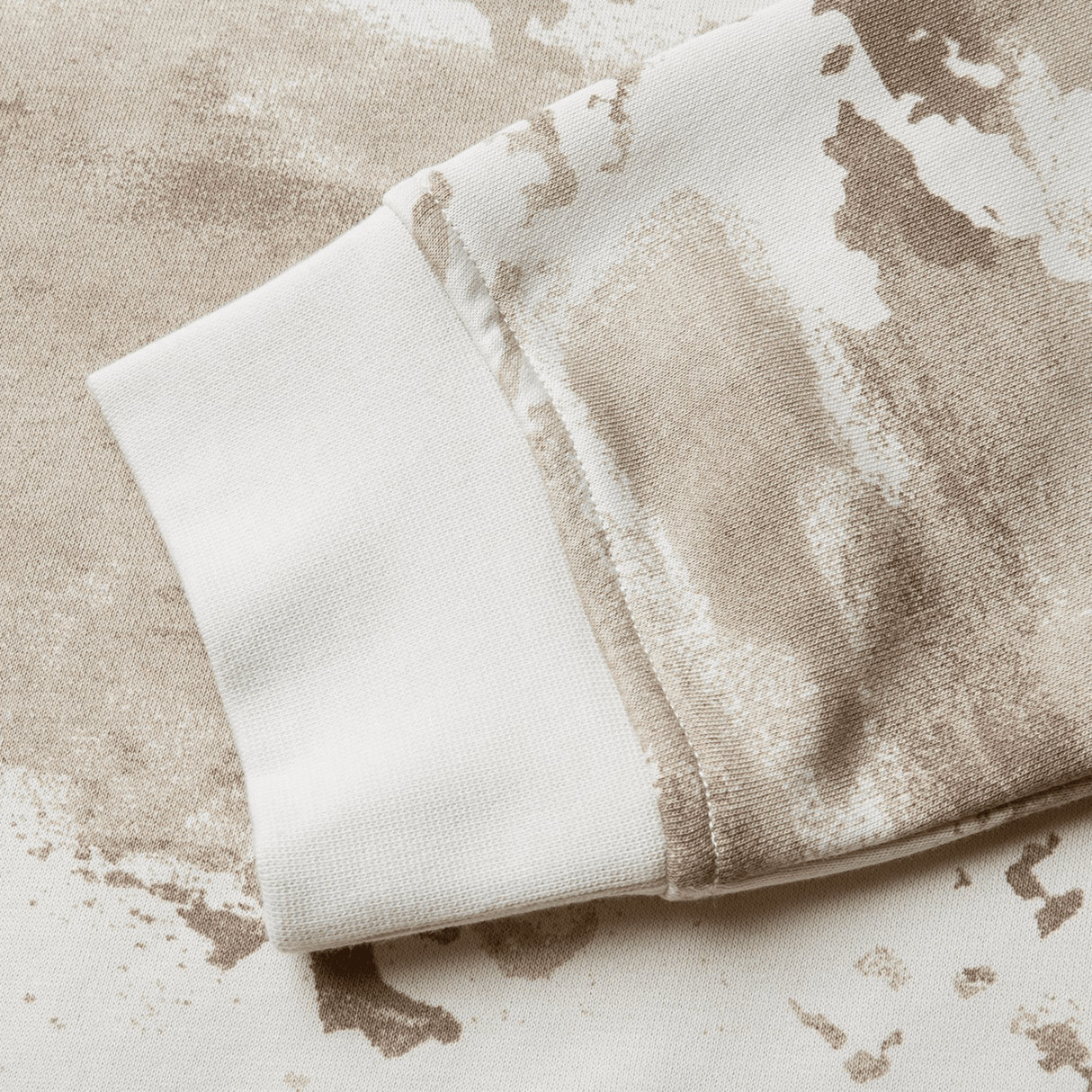 Close-up of a beige and white camouflage-patterned sleeve cuff on a fabric material from the British & Irish Lions 25 Camo Crew Sweatshirt by Canterbury, inspired by the storied heritage of the British & Irish Lions.
